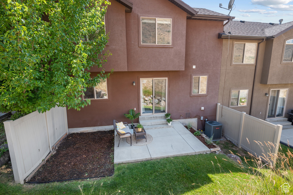 Rear view of house featuring stucco siding, a patio area, entry steps, and roof with shingles