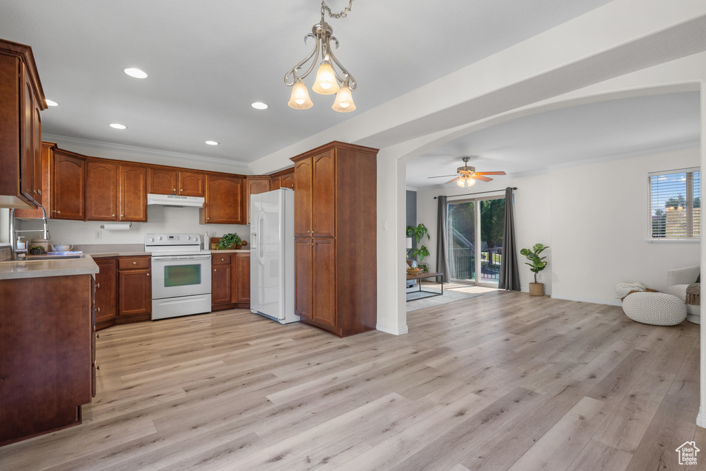 Kitchen featuring white appliances, open floor plan, under cabinet range hood, healthy amount of natural light, and recessed lighting