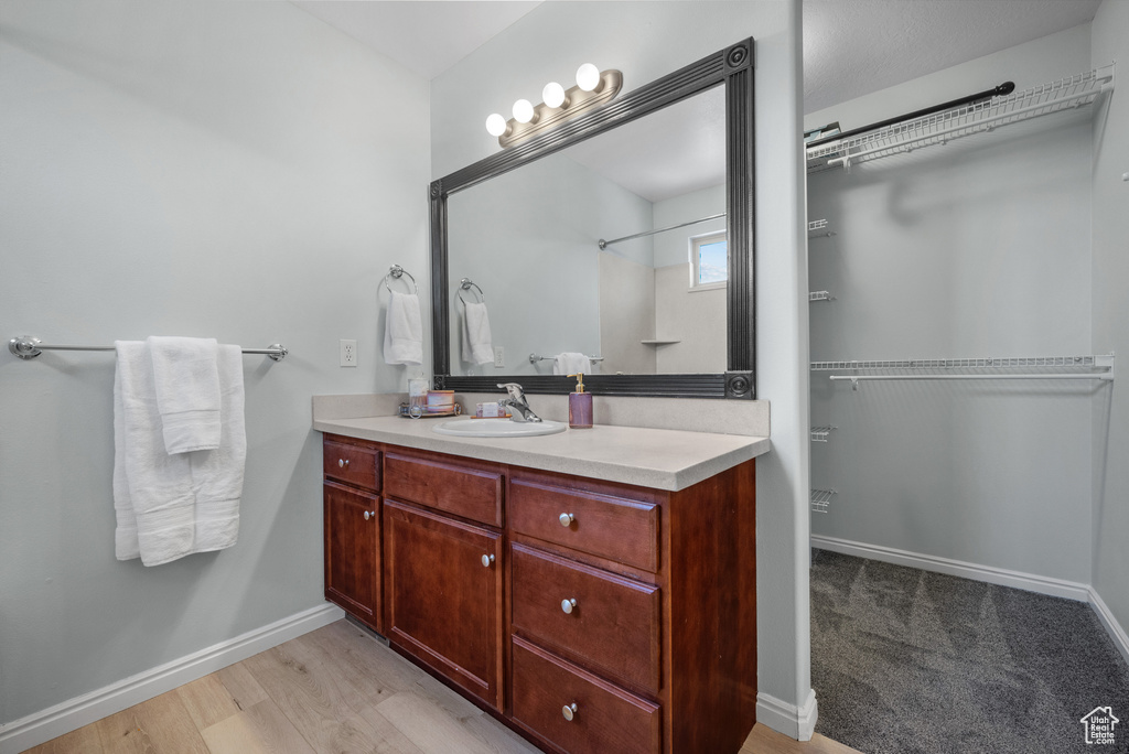 Full bath with vanity and a spacious closet