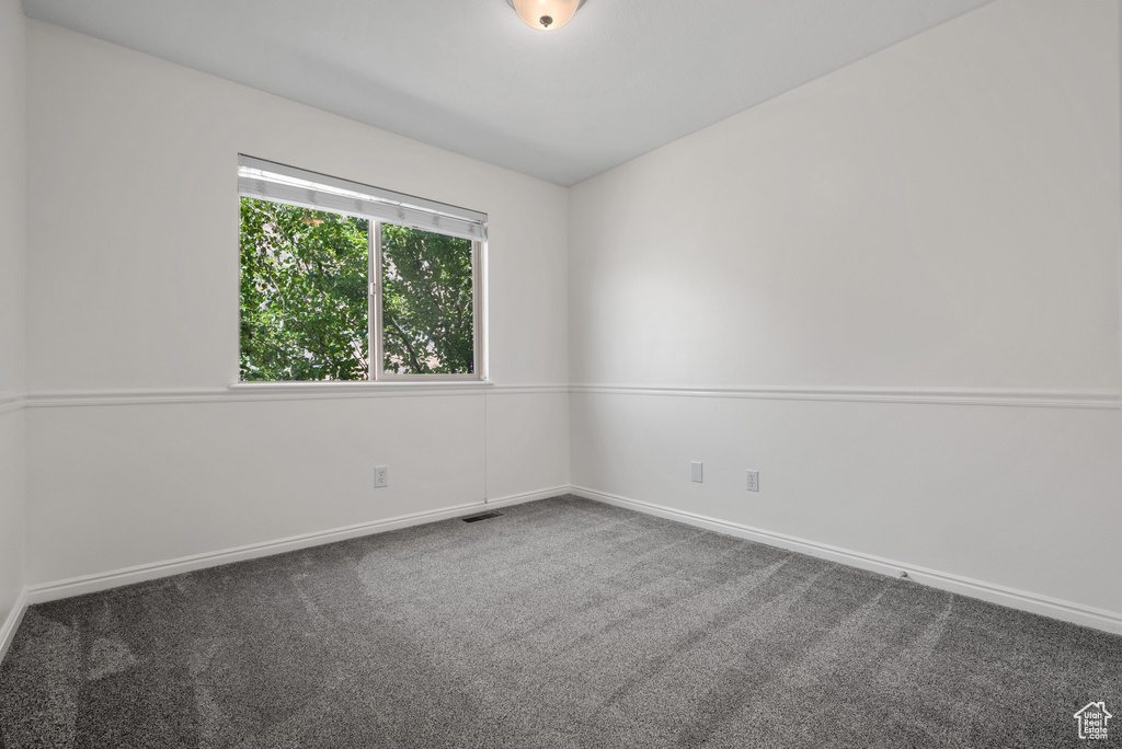 Carpeted empty room with baseboards