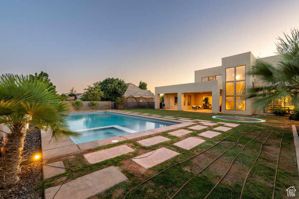 View of swimming pool with a patio area, a fenced backyard, and a pool with connected hot tub
