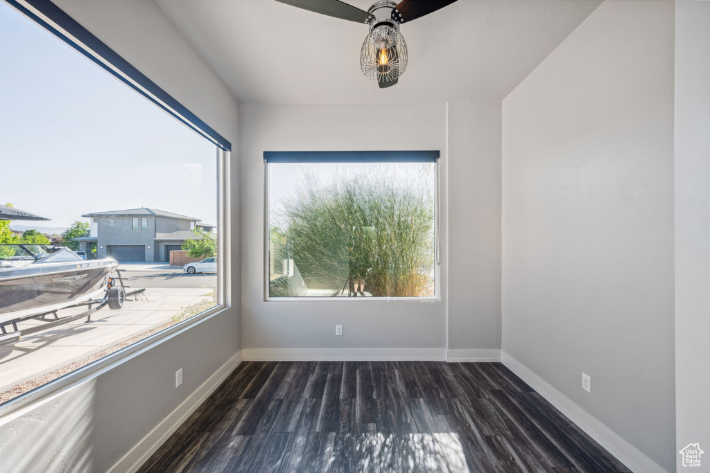 Unfurnished room with dark wood finished floors and a ceiling fan