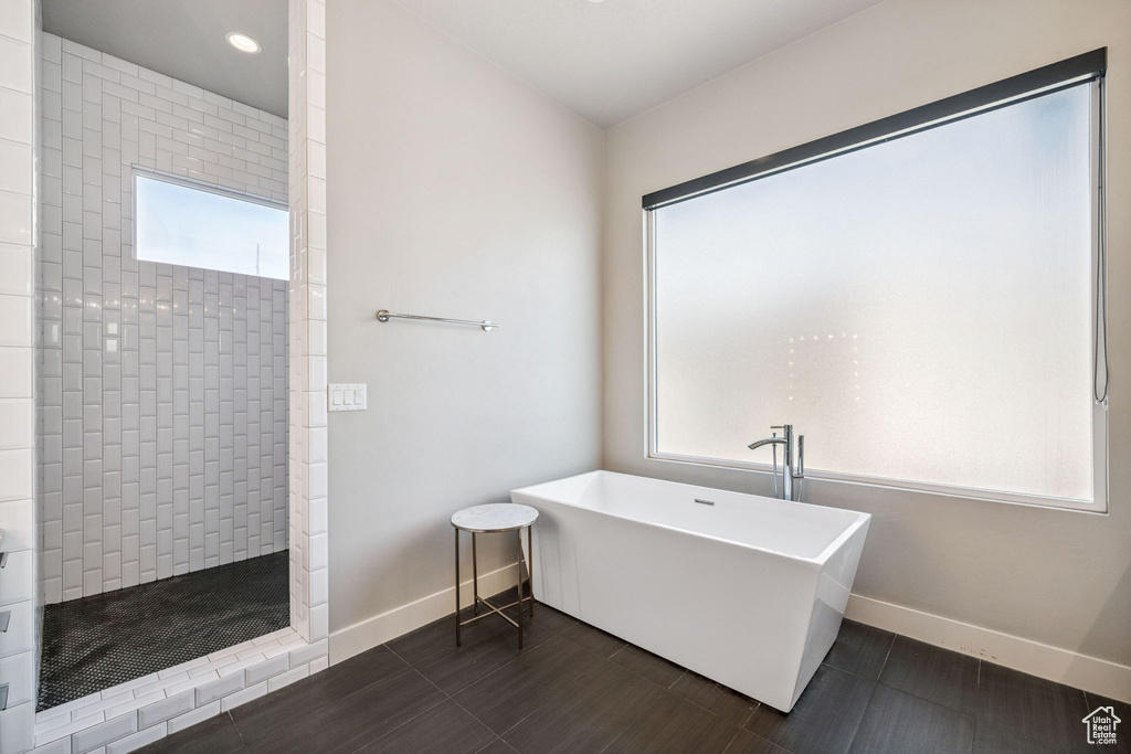 Full bath with a freestanding tub, plenty of natural light, a walk in shower, and recessed lighting
