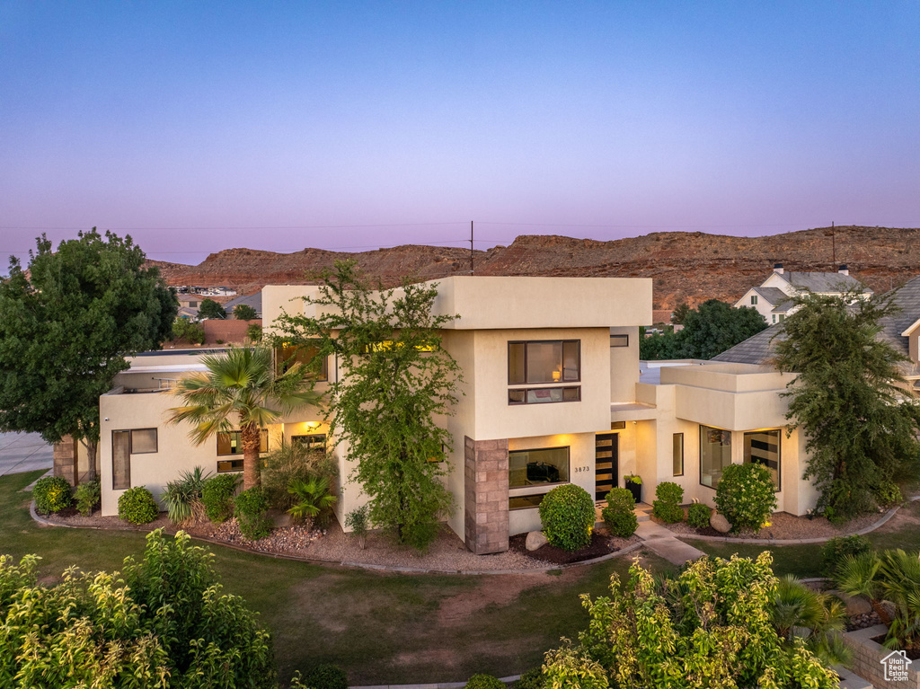 View of front of home featuring stucco siding, a mountain view, and stairway