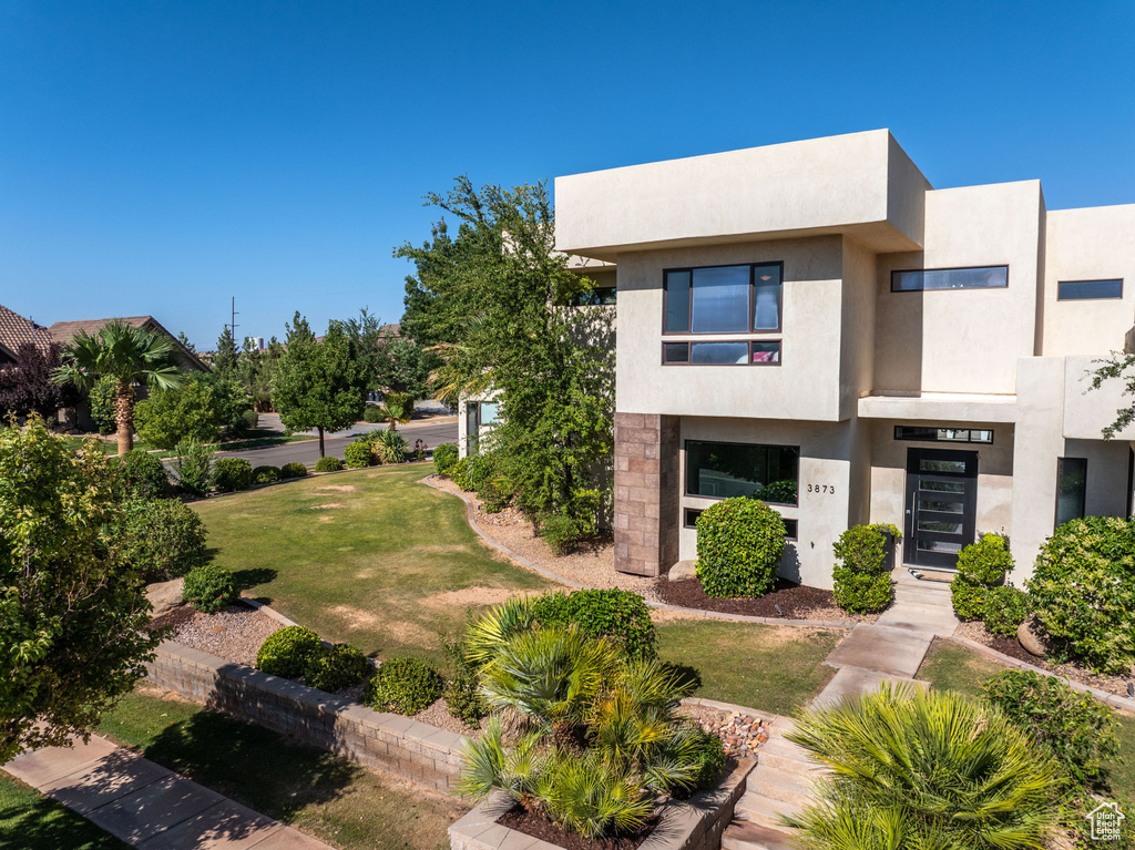 View of front of property featuring a front lawn and stucco siding