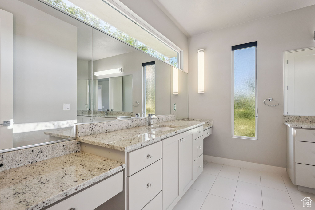 Bathroom with healthy amount of natural light, vanity, and tile patterned floors