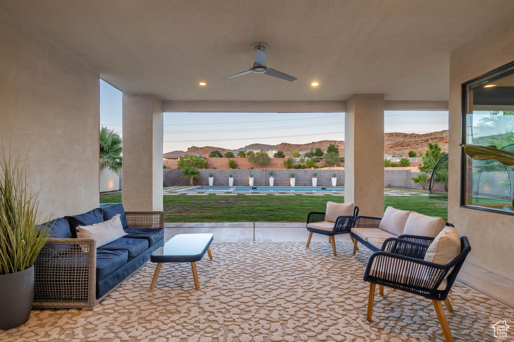 Fenced backyard featuring a patio, ceiling fan, and outdoor lounge area