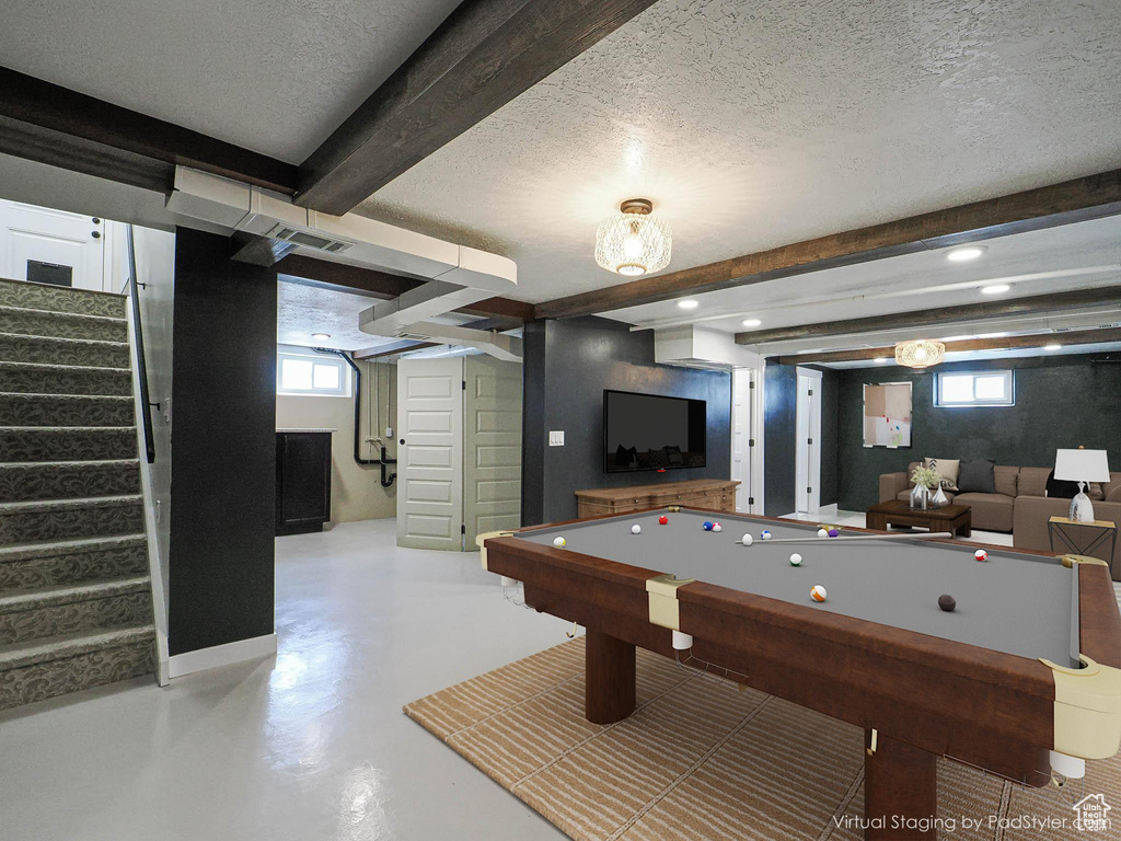 Playroom featuring beamed ceiling, finished concrete flooring, a textured ceiling, plenty of natural light, and billiards