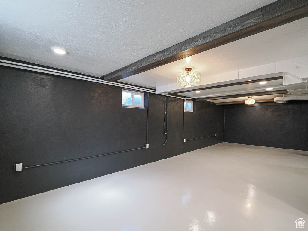 Below grade area with a textured ceiling and recessed lighting