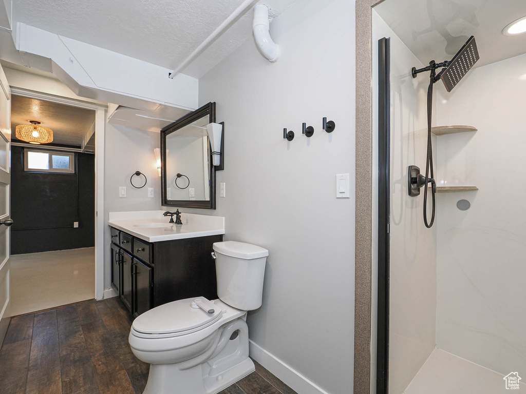 Bathroom with hardwood / wood-style floors, vanity, and a shower