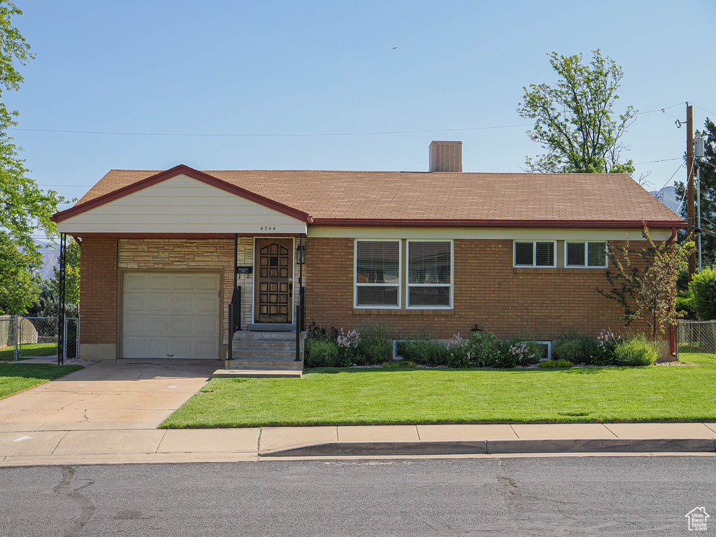 Ranch-style house with a garage, driveway, brick siding, and a chimney
