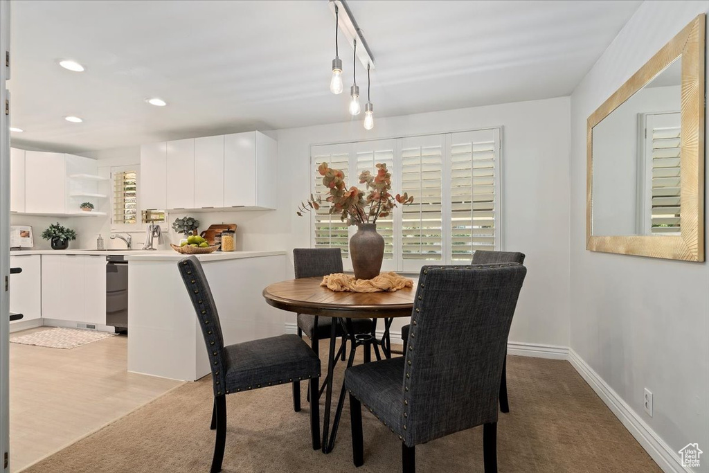 Dining room with recessed lighting, healthy amount of natural light, and light colored carpet
