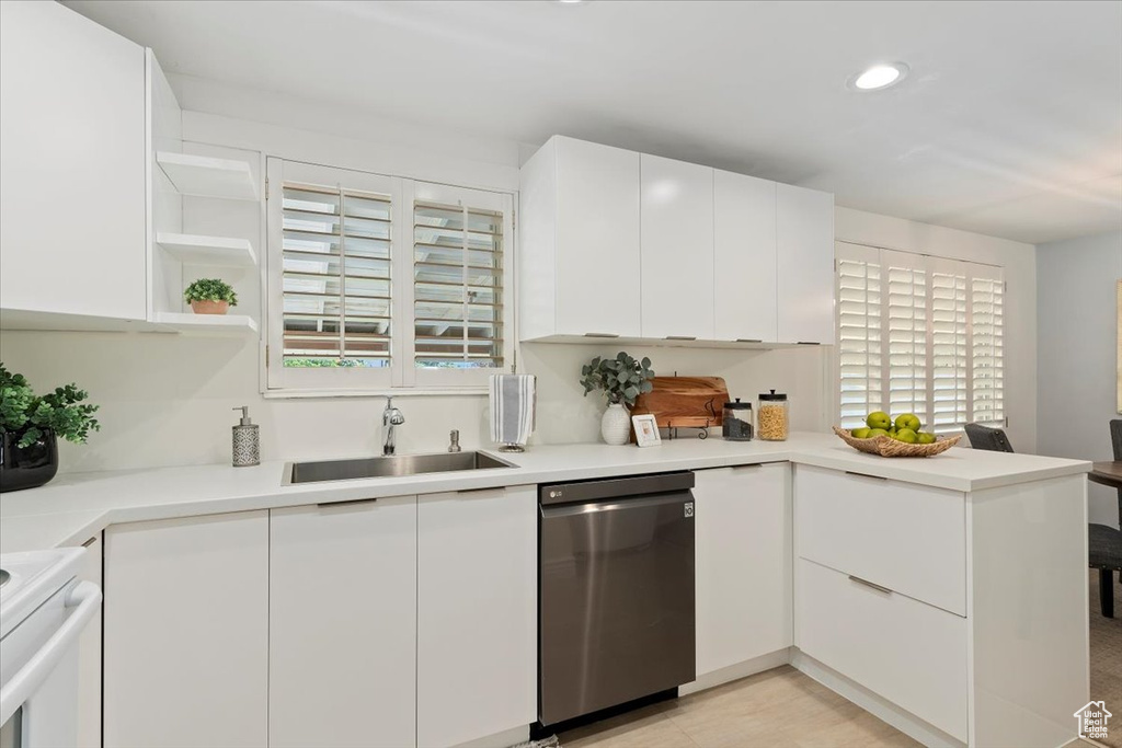 Kitchen featuring dishwasher, a peninsula, white cabinets, light countertops, and recessed lighting