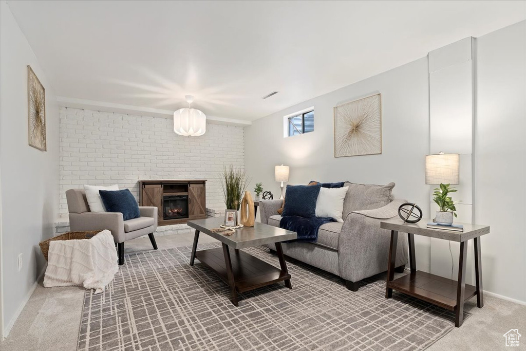 Living area featuring light colored carpet and a fireplace