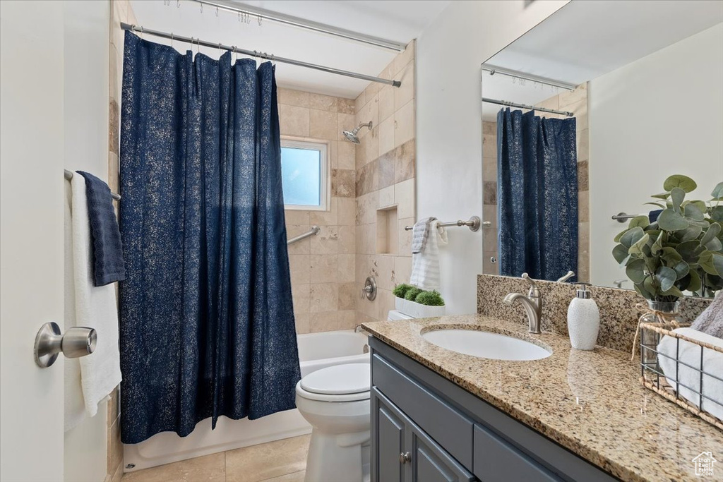 Bathroom with vanity, shower / tub combo, and tile patterned floors