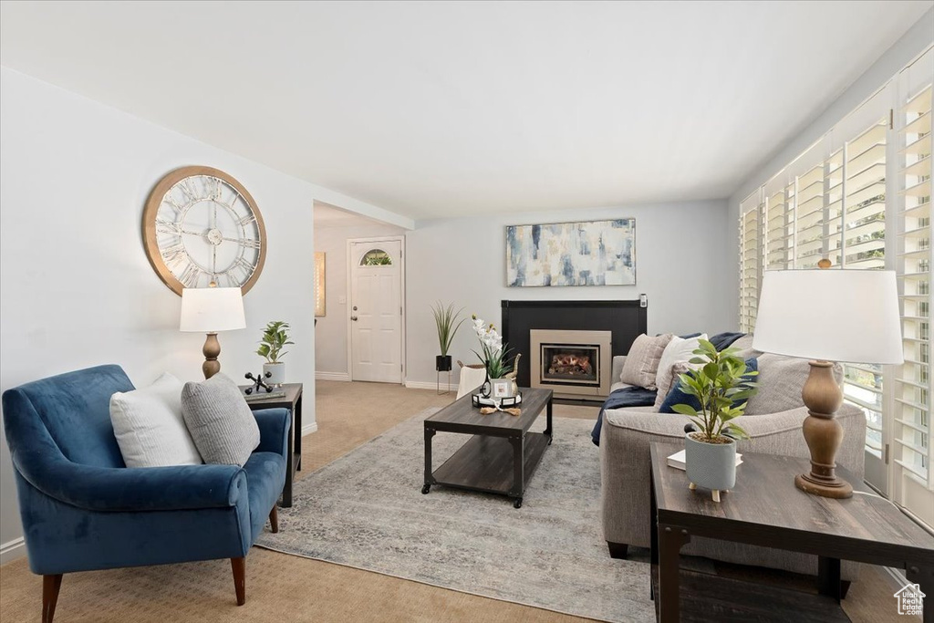 Carpeted living room with plenty of natural light and a fireplace
