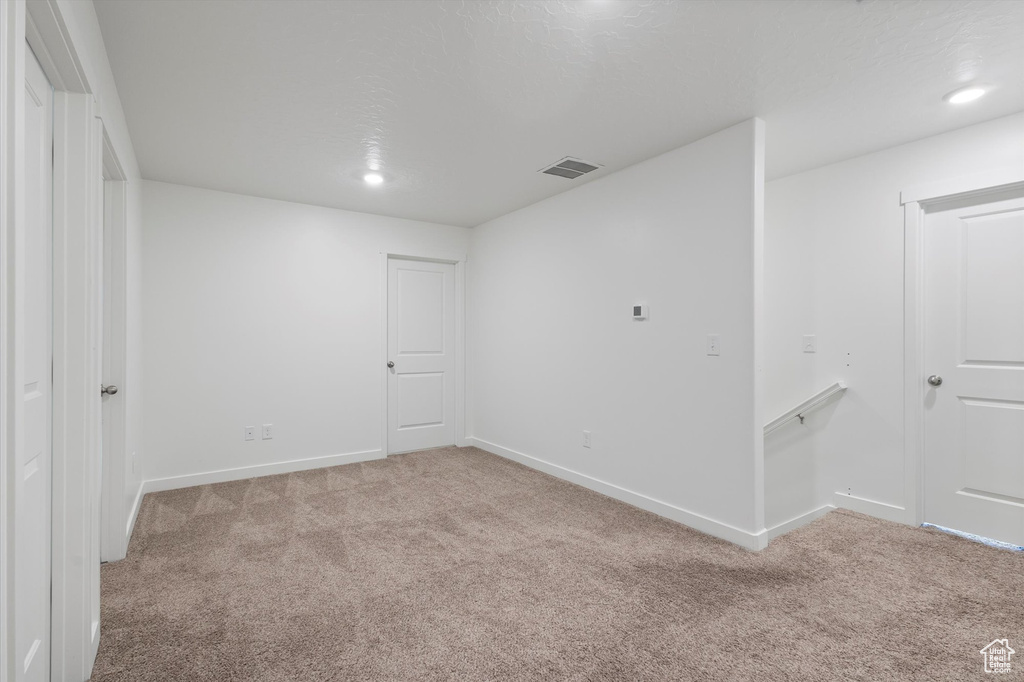 Carpeted spare room featuring baseboards and recessed lighting