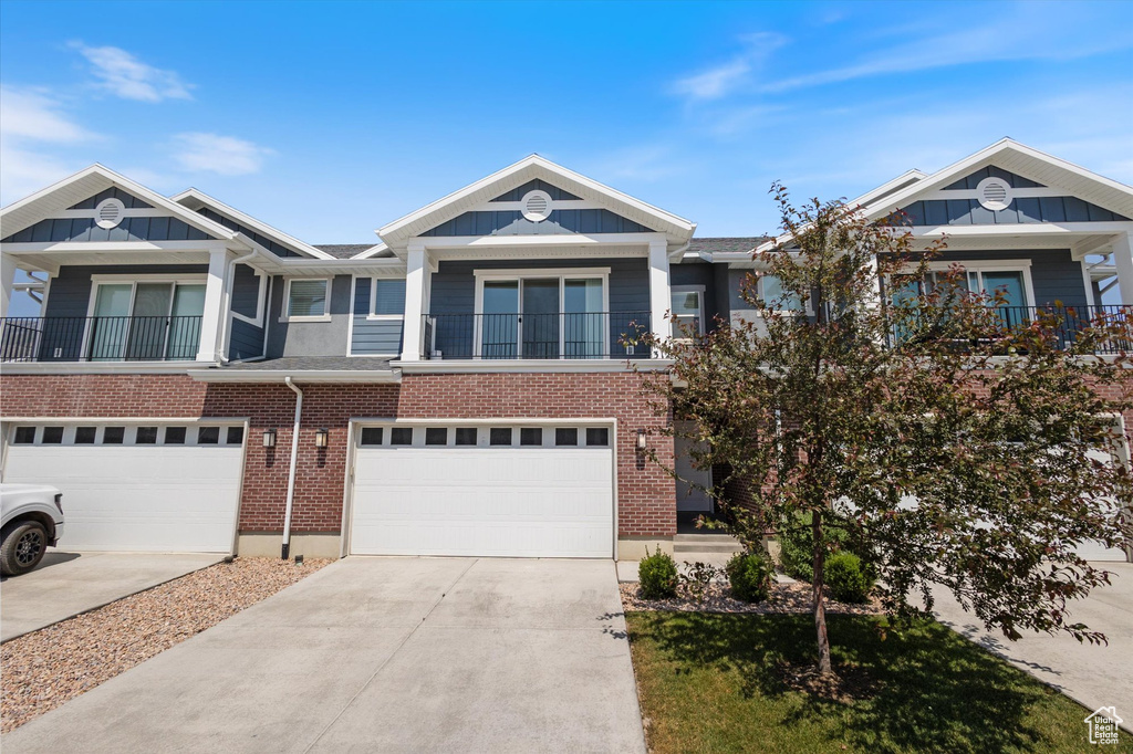 View of property with board and batten siding, a garage, and driveway