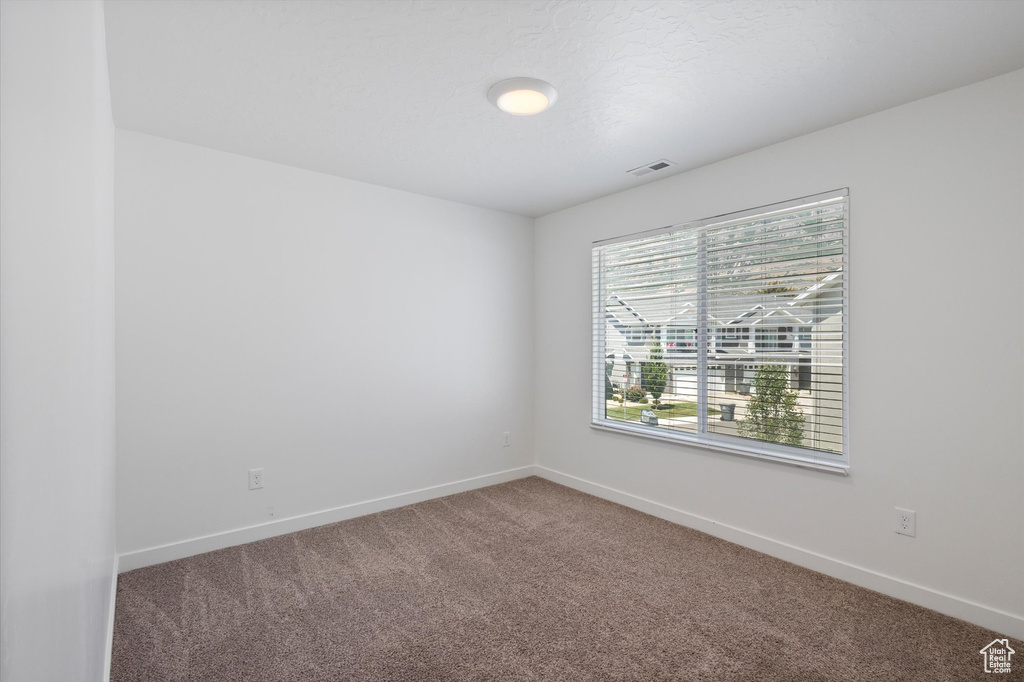 Empty room featuring carpet floors and baseboards