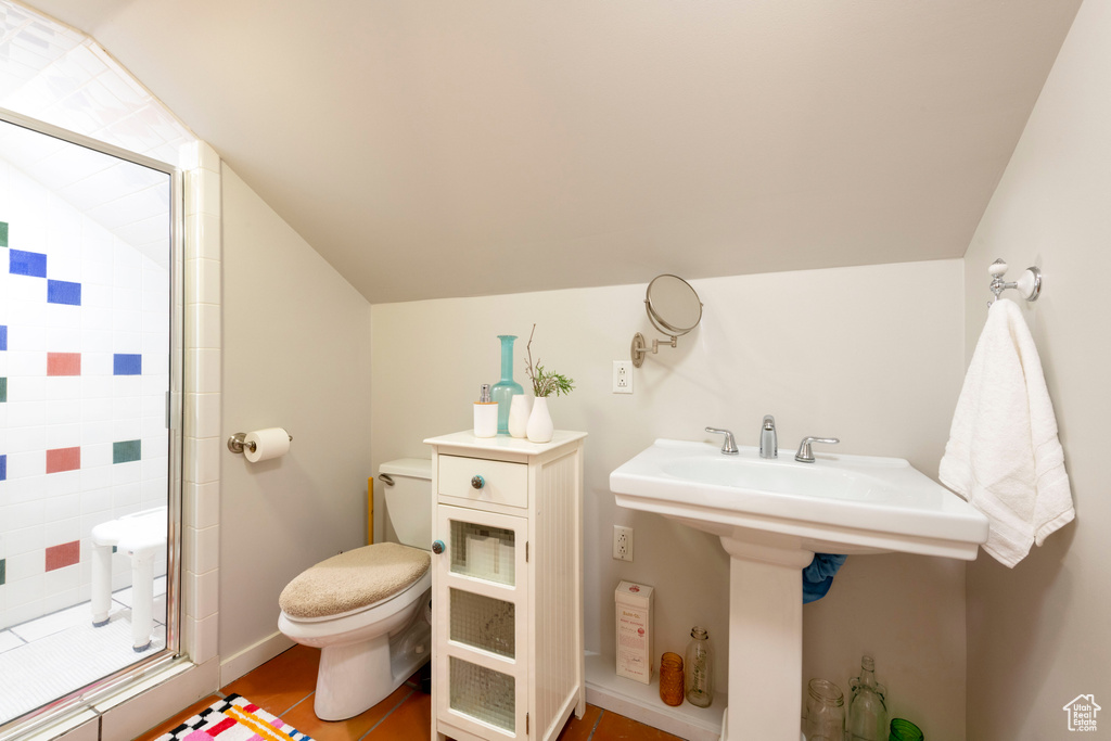 Bathroom with a shower stall and vaulted ceiling