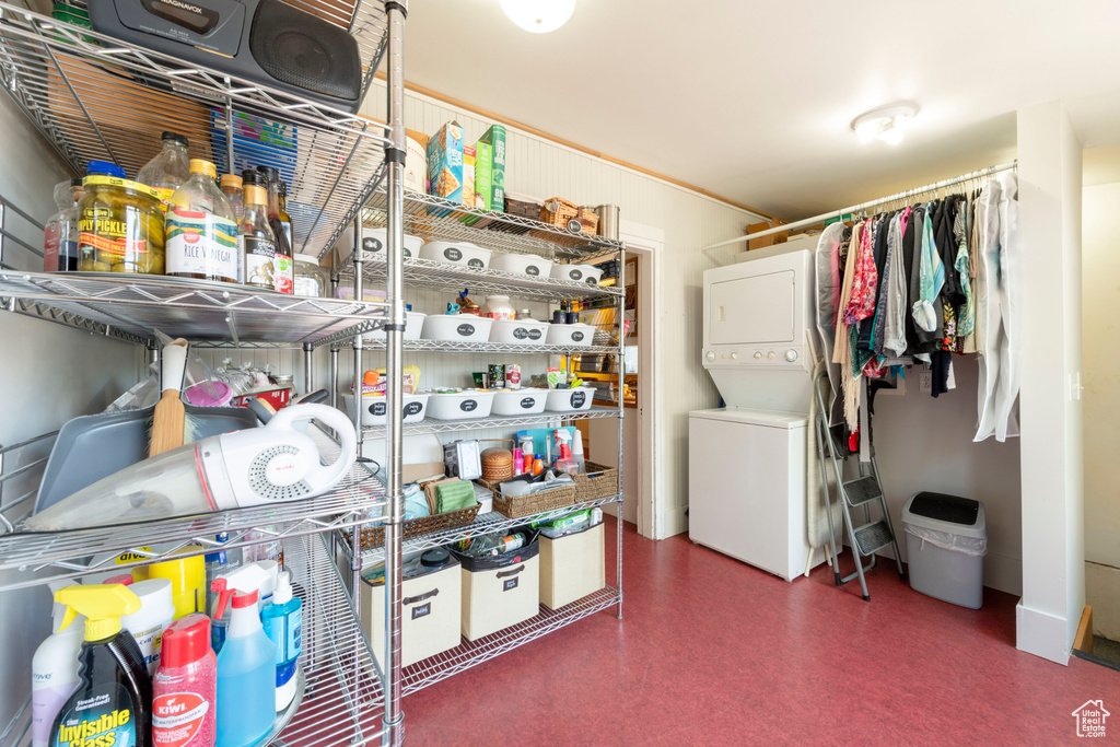 Storage room featuring stacked washer and clothes dryer