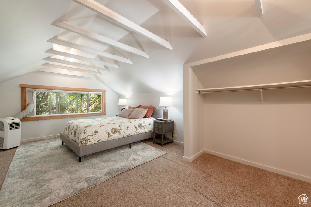 Carpeted bedroom featuring vaulted ceiling and baseboards