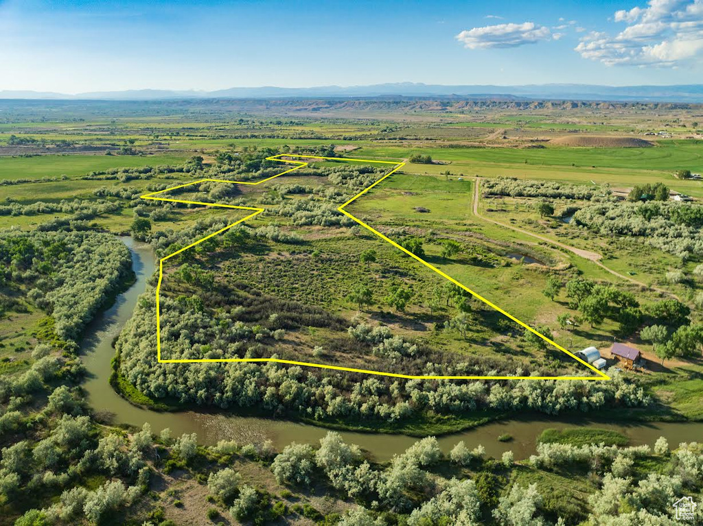 Aerial view of sparsely populated area with property parcel outlined and a mountain backdrop