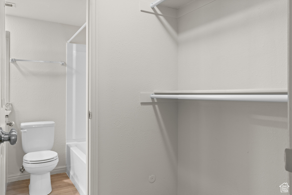 Full bathroom with wood finished floors and shower / washtub combination