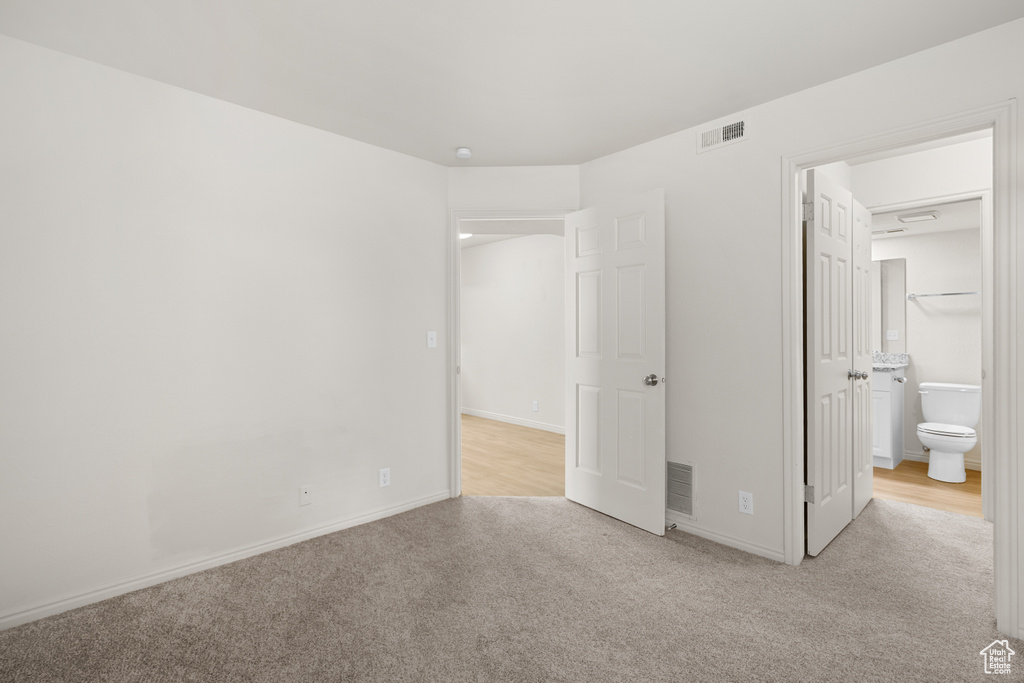Unfurnished bedroom featuring carpet floors and connected bathroom