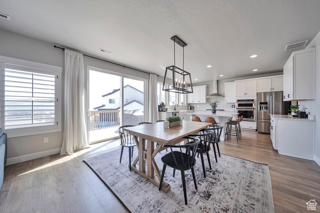 Dining room with healthy amount of natural light, light wood finished floors, and recessed lighting