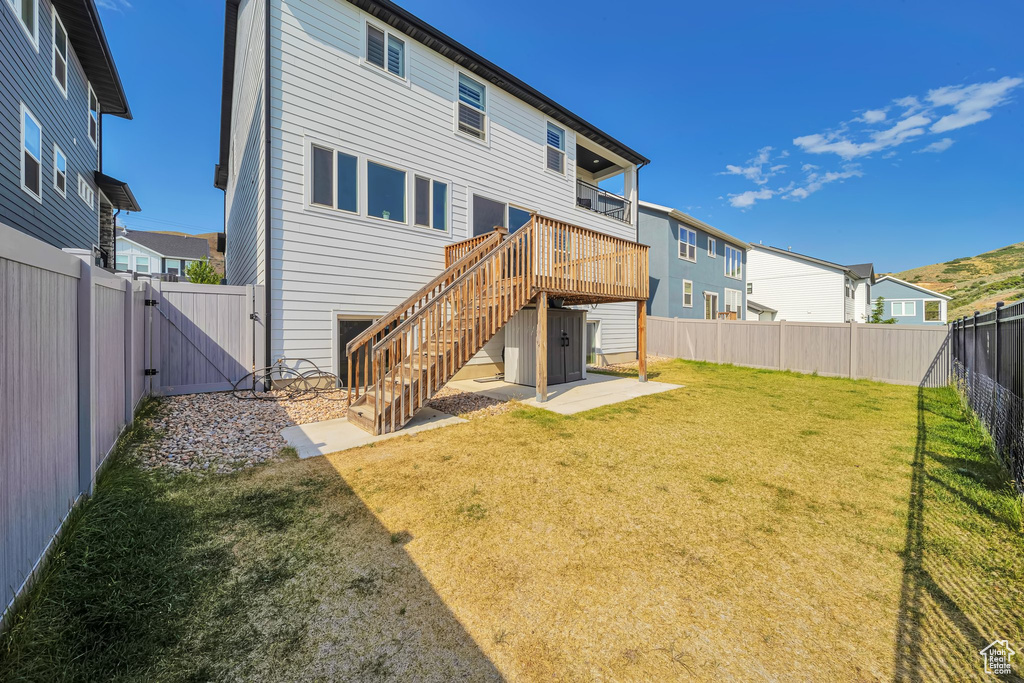Rear view of house with a gate, a fenced backyard, stairs, a wooden deck, and a patio area