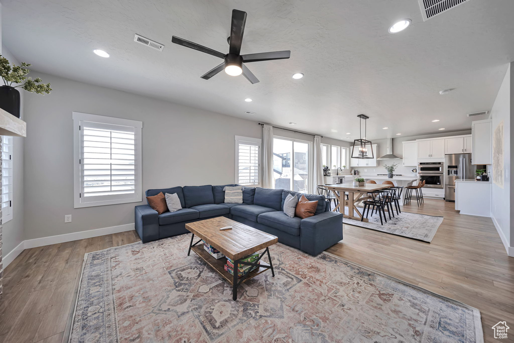 Living area featuring a ceiling fan, light wood-style flooring, and recessed lighting