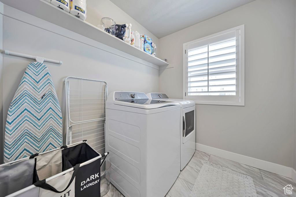 Washroom with independent washer and dryer and light marble finish floors