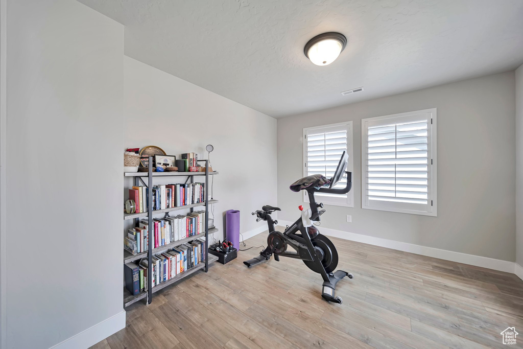 Workout room with baseboards and wood finished floors