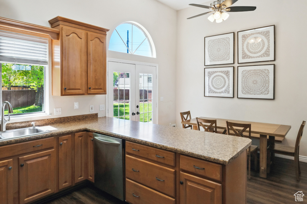 Kitchen with dishwasher, a sink, a peninsula, dark wood-type flooring, and french doors
