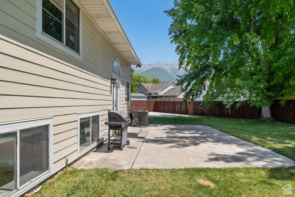 Fenced backyard with area for grilling, a mountain view, and a patio area