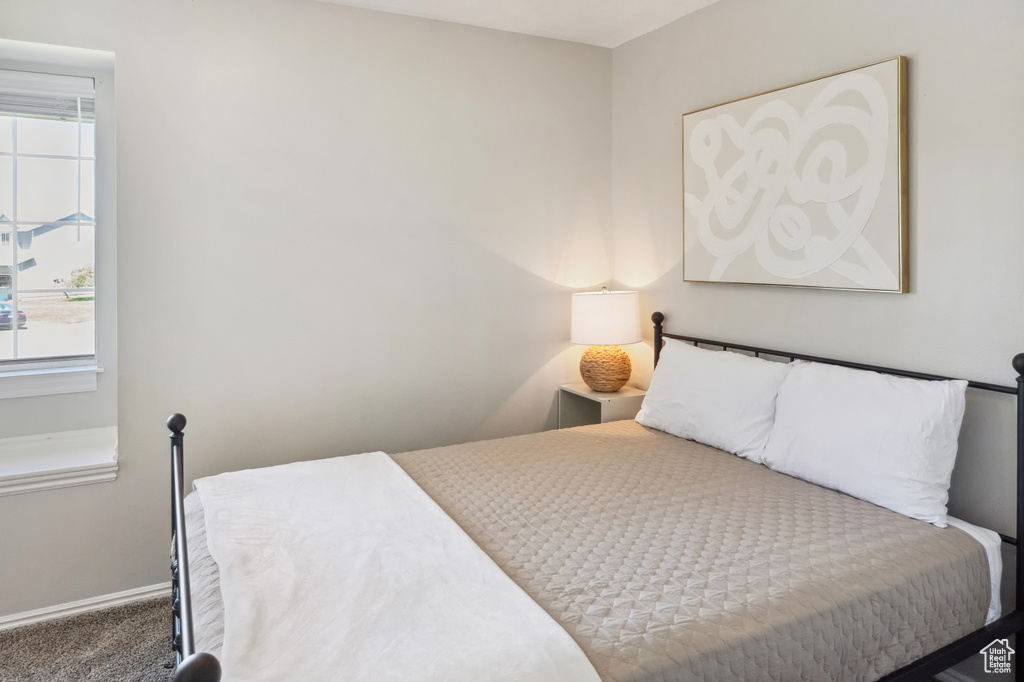 Bedroom featuring carpet and baseboards