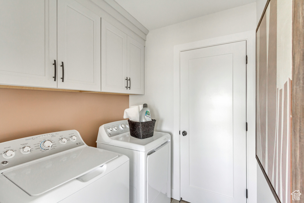 Washroom featuring washer and clothes dryer and cabinet space