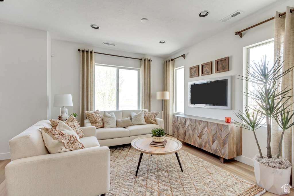 Living room with light wood-style floors and recessed lighting