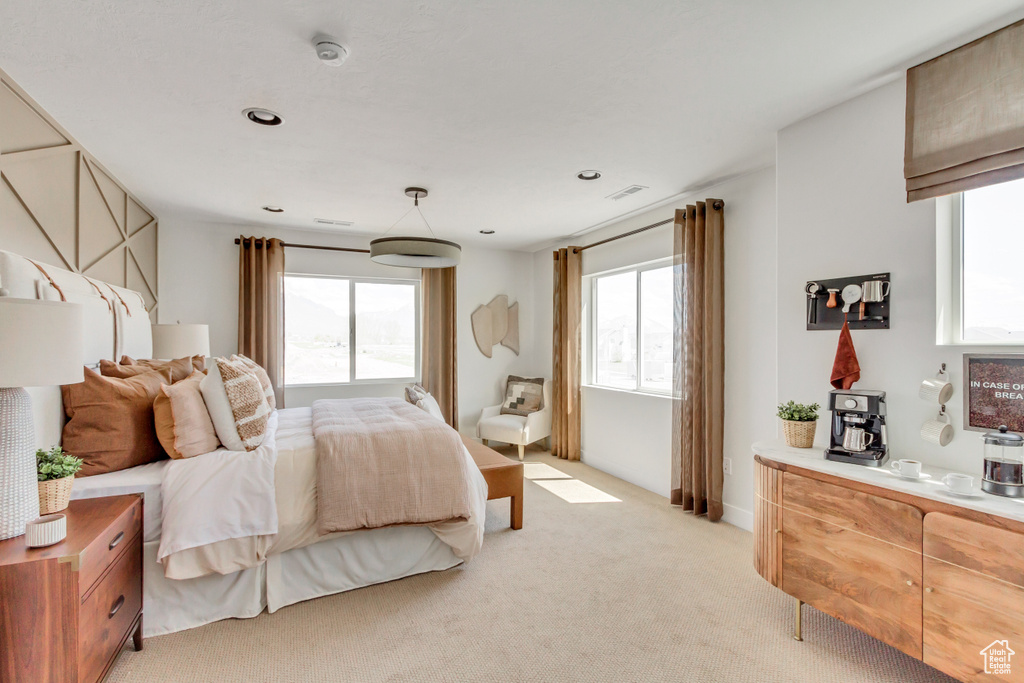 Bedroom with multiple windows and light colored carpet