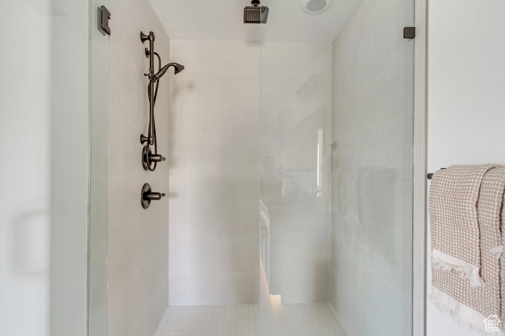 Full bath featuring a shower stall and tile walls