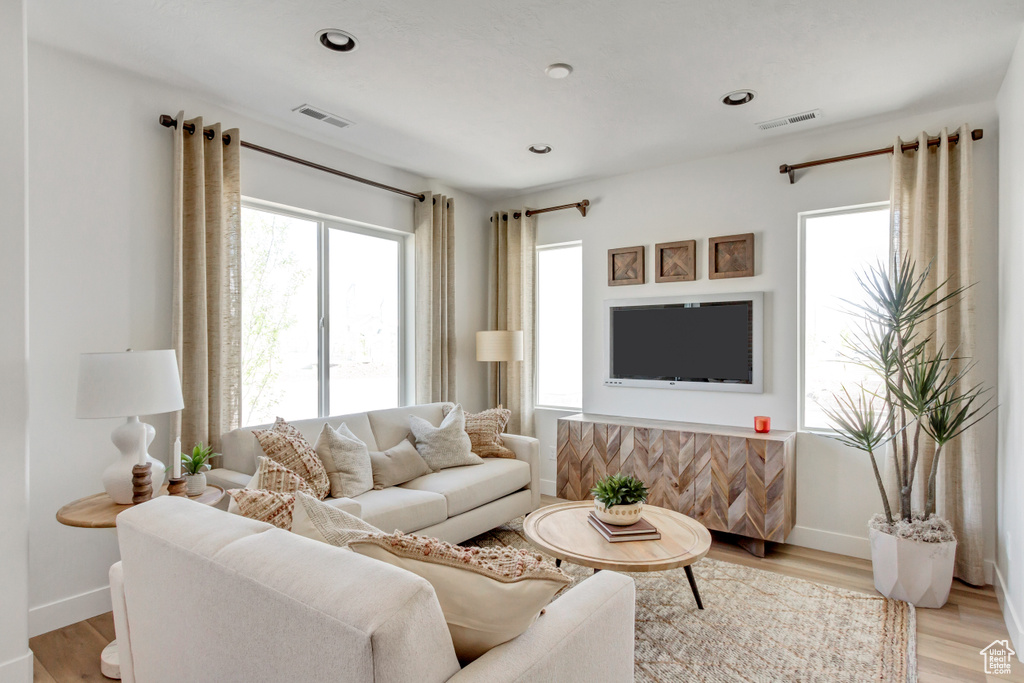 Living area with healthy amount of natural light, light wood-type flooring, and recessed lighting