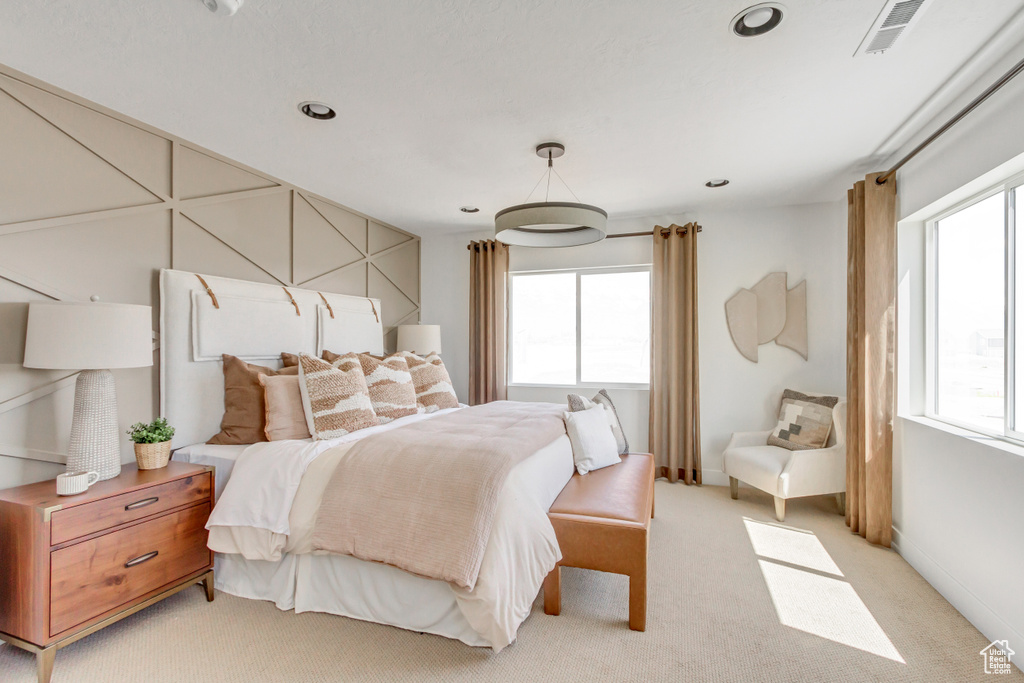 Bedroom with light colored carpet and recessed lighting