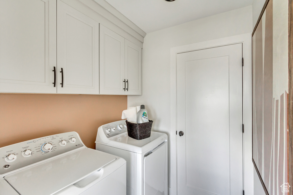Washroom featuring washer and clothes dryer and cabinet space