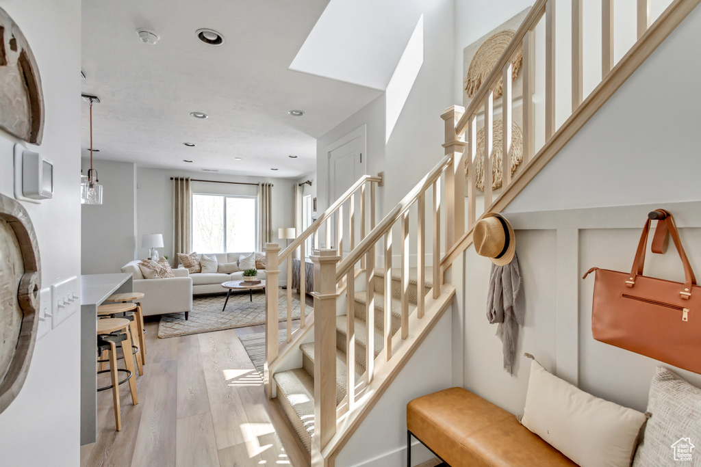 Stairs featuring wood finished floors and recessed lighting