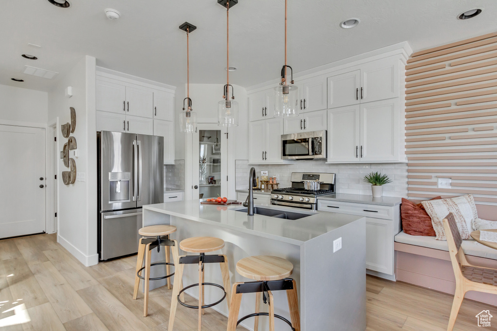 Kitchen featuring stainless steel appliances, light wood finished floors, decorative backsplash, and recessed lighting