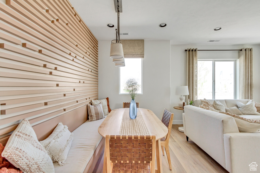 Dining room with light wood-style floors and recessed lighting