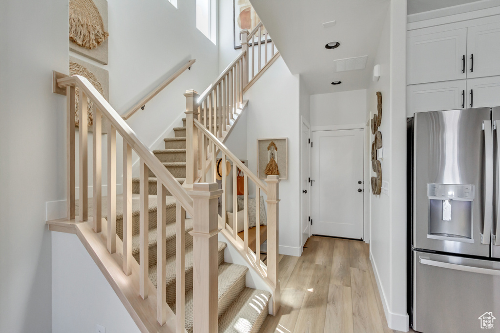 Stairway with wood finished floors and baseboards