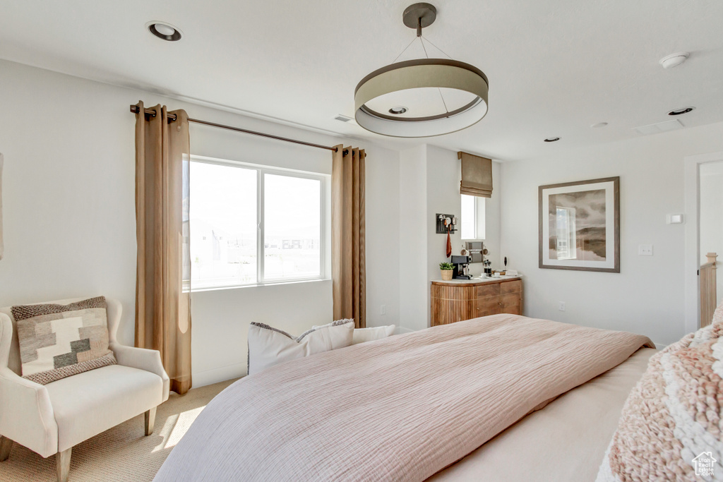 Bedroom featuring multiple windows and light colored carpet