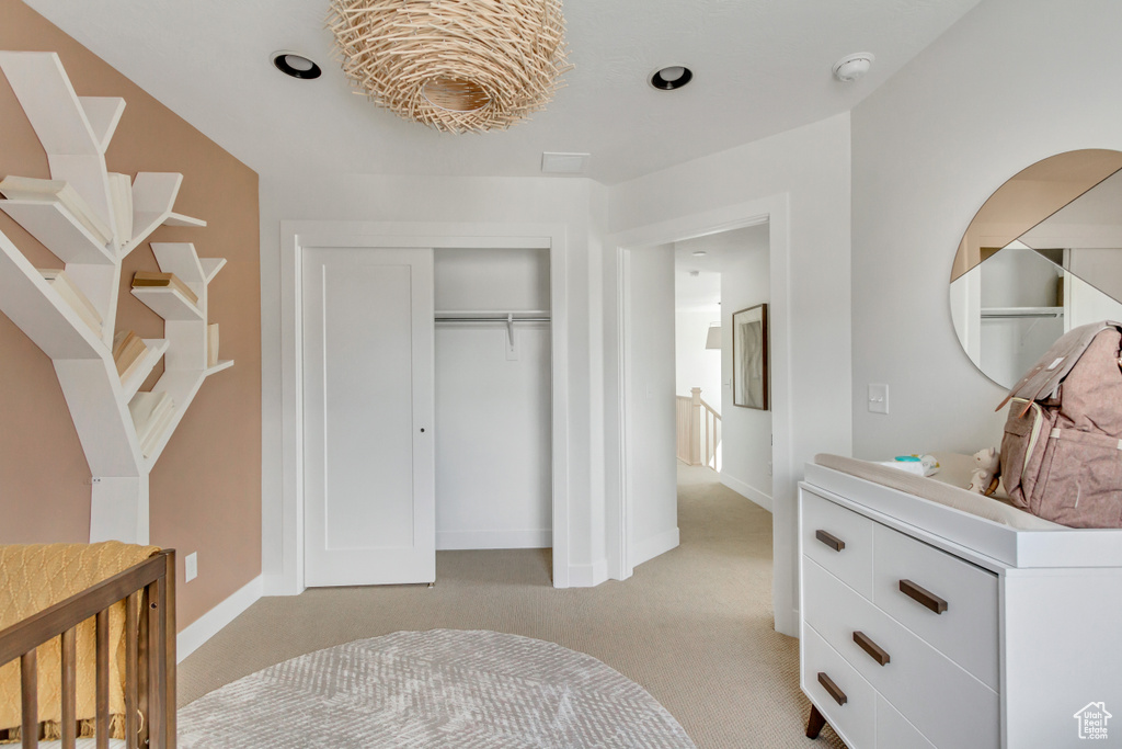 Bedroom with light carpet and a closet